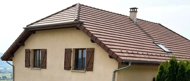 Toit en tuiles brunes avec fenêtre de toit sur une maison d'Éloise dans l'Ain